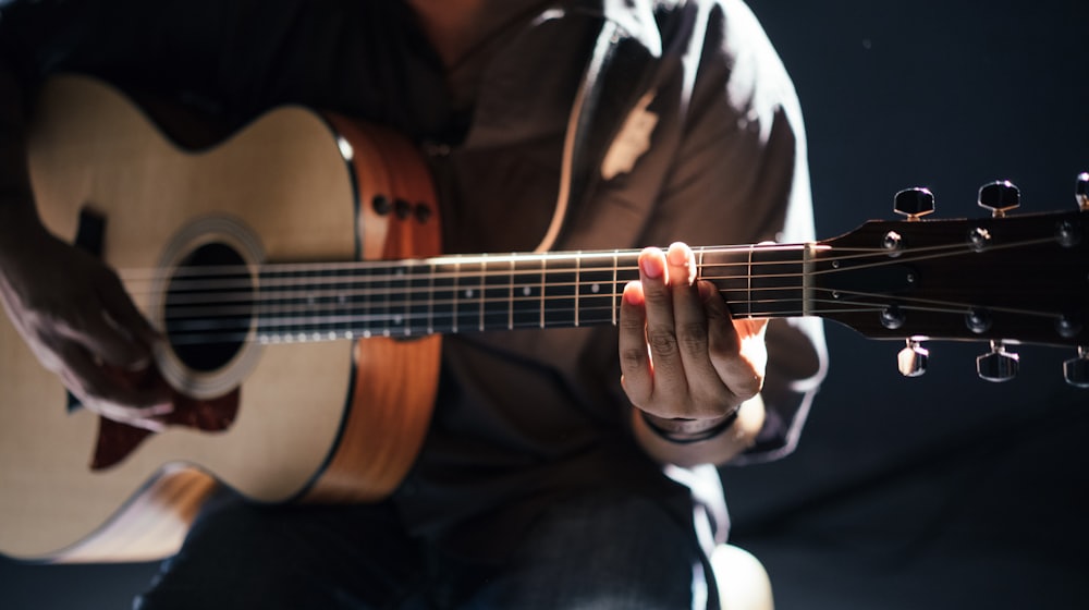 Hands playing a Portuguese guitar